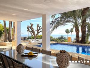a dining room with a table and a swimming pool at VH CostaBlanca - EVA in Benissa