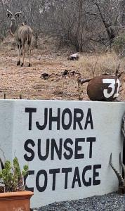 un segno per un rifugio teton sunset con un cervo sullo sfondo di Tjhora Sunset Cottage a Cambridge