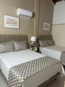 a bedroom with two beds and a air conditioner on the wall at HNH Hotel Luxury Experiencia Vip in San Andrés +28 photos