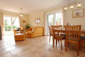 a living room with a couch and a table and chairs at Waldstrasse 15 Haus Seepferdchen in Zingst