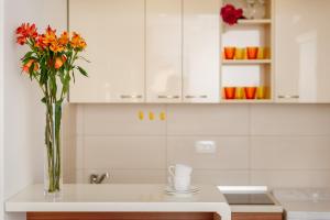 a vase of flowers on a counter in a kitchen at Apartments Blue Sea in Kotor +43 photos