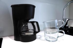 a coffee maker and a glass of water on a counter at Henniina V Karjasilta in Oulu