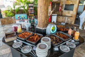 a buffet with several trays of food on a table at El Aram Imirá Beach Resort in Natal