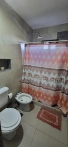 a bathroom with a toilet and a shower curtain at Alquilo habitación hasta 2 personas en vivienda familiar in Estancia Vieja
