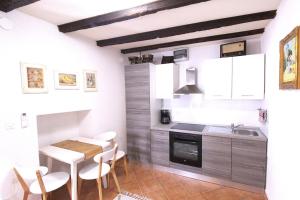a kitchen with a table and chairs and a sink at Sea view apartment Umag 1 in Umag