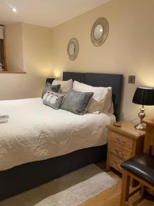 a bedroom with a large bed with pillows on it at Little Howle Farm Barn in Ross on Wye
