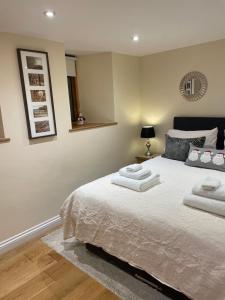 a bedroom with a bed with two towels on it at Little Howle Farm Barn in Ross on Wye +24 photos