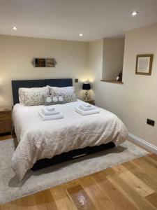 a bedroom with a large bed with two towels on it at Little Howle Farm Barn in Ross on Wye