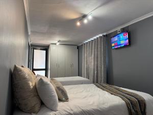 a bedroom with two beds and a tv on the wall at Heaven in Cape Town