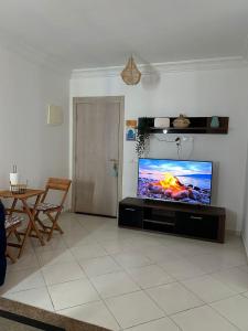 a living room with a large flat screen tv at cozy apartment with pool in Ed Dechiouar