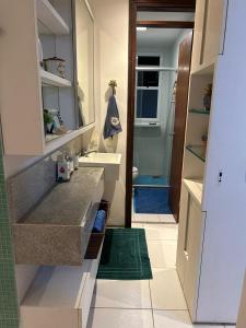 a small bathroom with a sink and a mirror at Apartamento com cobertura no Portamaris Resort in Aquiraz