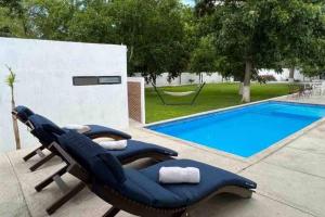 un par de sillones junto a una piscina en Quinta Maderoo 5, en Parras de la Fuente