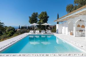 a swimming pool in a villa with blue water at Villa Seascape, Beachfront Living in the Greek Riviera Porto Heli in Porto Heli +37 photos