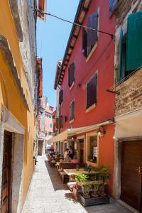an alley in an old town with tables and buildings at Apartment Marconi in Rovinj