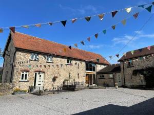 a brick building with flags hanging from it at Little Howle Farm Barn in Ross on Wye