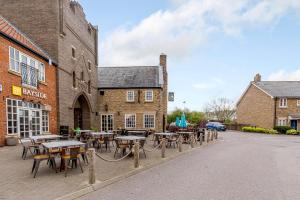 a group of tables and chairs in front of a building at Dotty's Sunshine Cottage in Reighton
