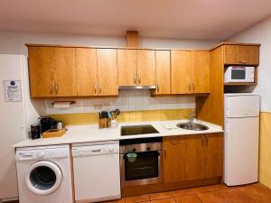 a kitchen with wooden cabinets and a white refrigerator at Apartamento Acogedor Pineta in Bielsa
