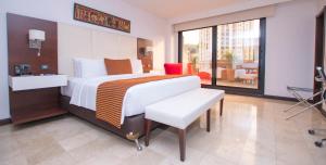 a hotel room with a bed and a balcony at Hotel Dann Carlton Cali in Cali