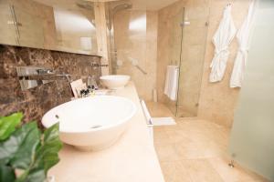 a bathroom with a large white sink and a shower at Hotel Dann Carlton Cali in Cali