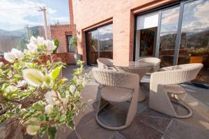 a patio with wicker chairs and a table at Hotel Dann Carlton Cali in Cali