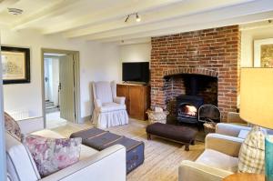 un soggiorno con camino in mattoni di Grints Cottage a Burnham Thorpe