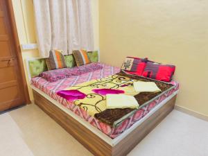 a bed with colorful sheets and pillows on it at Shritik Homestay in Ratnagiri