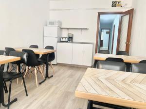 Una habitación con mesas y sillas y una cocina. en Hostal La Sierra Cabárceno, en Sarón