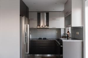 a kitchen with black and white cabinets and a refrigerator at Cozy beach home in Faros 2 in Rákhai