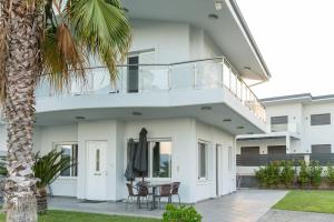 a white house with a balcony and a table and chairs at Cozy beach home in Faros 2 in Rákhai