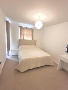 Un dormitorio blanco con una cama y una ventana. en Luxury Apartment Oxford, en Abingdon