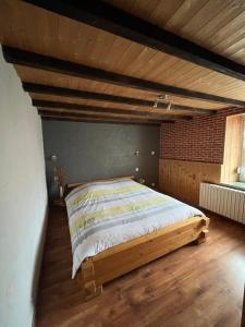 a large bed in a room with a wooden ceiling at ferme des grands blaise in La Bresse