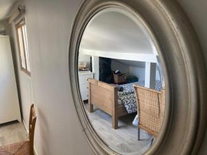 a mirror reflecting a bedroom with a bed and a desk at Maison avec vue sur Paris et la Tour Eiffel in Champigny-sur-Marne