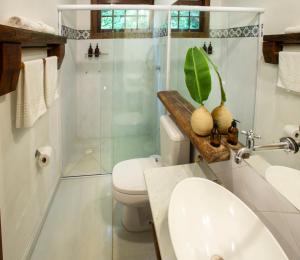 a bathroom with a toilet and a shower and a sink at Pousada Santa Martha in Ubatuba