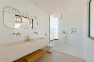 une salle de bain blanche avec lavabo et douche dans l'établissement Villa Calma by Aura Collection, à Lajares 38 autres photos