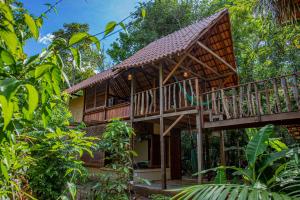 a wooden house with a deck in the woods at Suíte Curuaçu in Santarém