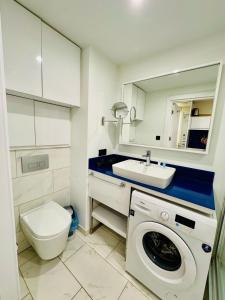 a bathroom with a toilet and a sink and a washing machine at Orbi city dream city block A in Batumi +18 photos