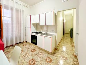 a kitchen with white cabinets and a sink at Casa La Saletta in Torrenova