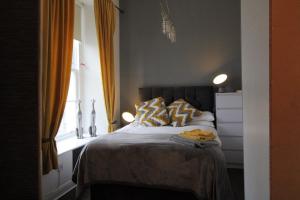 a bedroom with a bed with two pillows and a window at Ayr Apartment with Sea and Countryside views in Ayr +35 photos