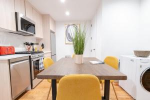 ブルックリンにある323-1 Spacious 2BR Williamsburgの木製テーブルと黄色い椅子付きのキッチン