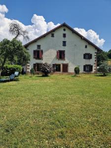 a large white house with a large grass field at Chevaux au Soleil in Fresse