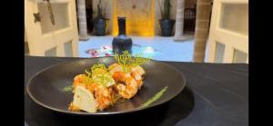 a plate of food with shrimp on a table at Riad MALAÏKA in Essaouira