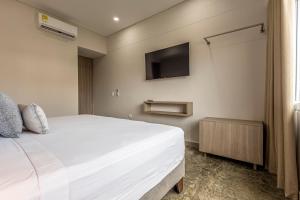a bedroom with a bed and a tv on the wall at Apartamento De La Cruz Con Rooftop By SoHo in Cartagena de Indias +4 photos