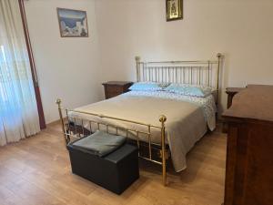 a bedroom with a bed and a ottoman in it at Casa Del Sole in Pimonte