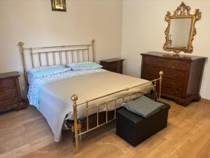 a bedroom with a bed and a dresser and a mirror at Casa Del Sole in Pimonte
