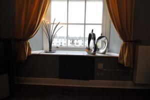 a window with a vase and a mirror on a window sill at Ayr Apartment with Sea and Countryside views in Ayr