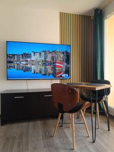 a living room with a flat screen tv on a wall at Studio les Hauts de Honfleur in Équemauville