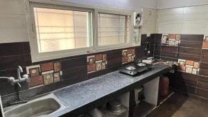 a kitchen with a counter and a sink and a window at Khaleel Manzil Luxe Stays in Hyderabad +16 photos