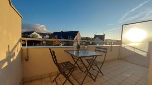 a small balcony with a table and chairs on it at Au Clair De Lune in Pléneuf-Val-André