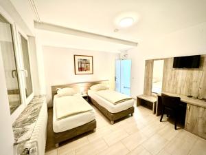 a hotel room with two beds and a television at Hotel Soad in Salach