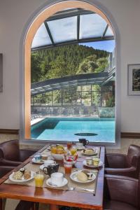 a table with food and a view of a pool at Les Jardins De La Glacière in Corte